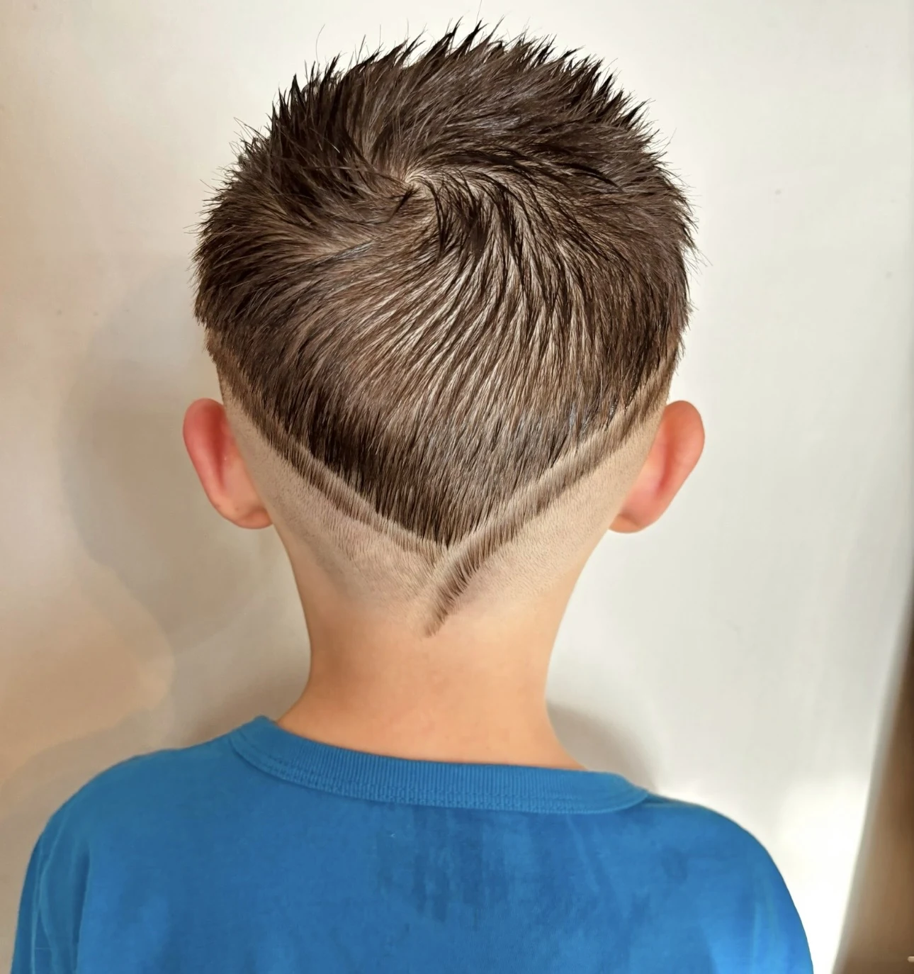 Short haircut with clean V-shaped shaved line design