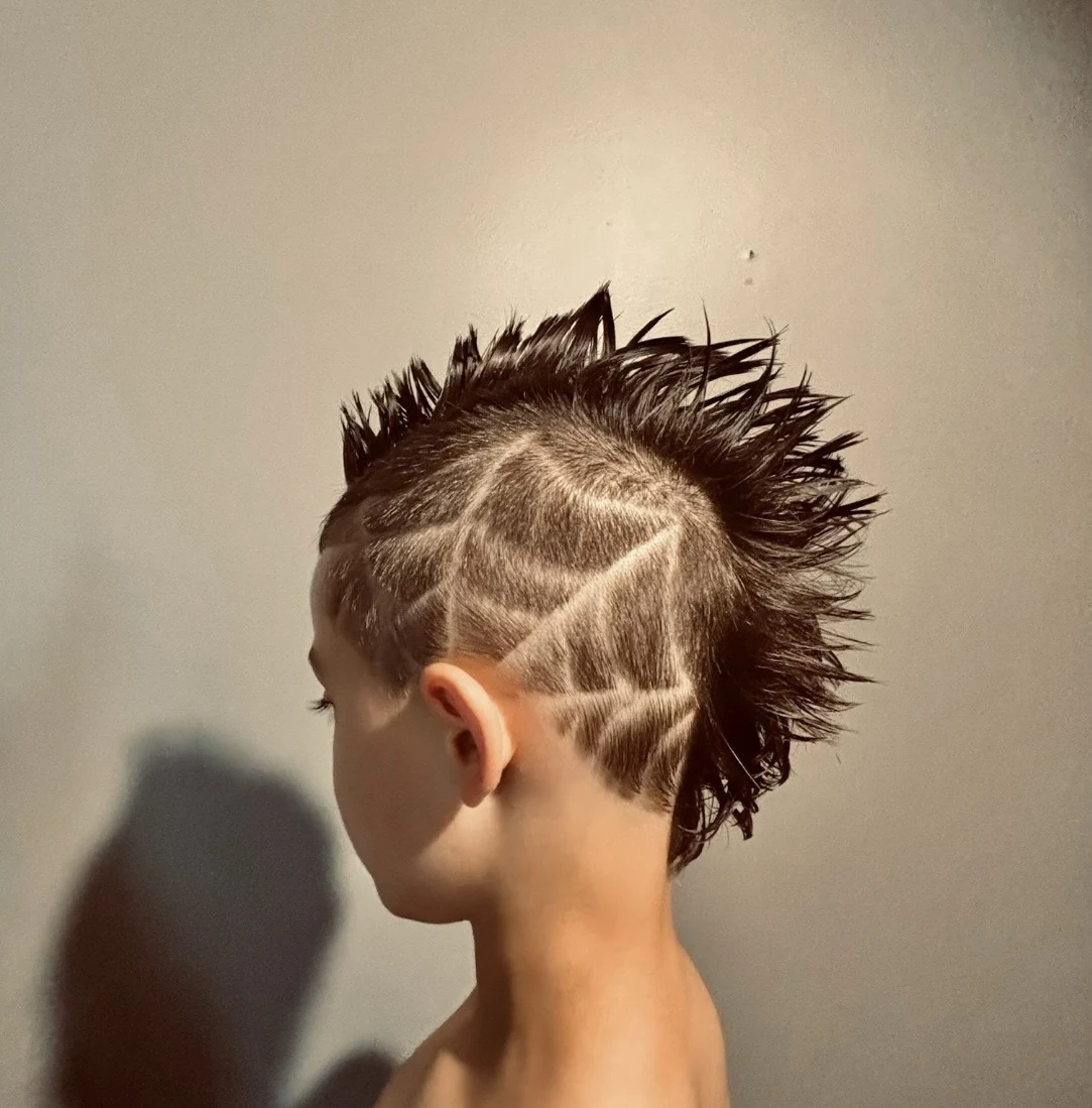 Spiked mohawk haircut with geometric shaved line design